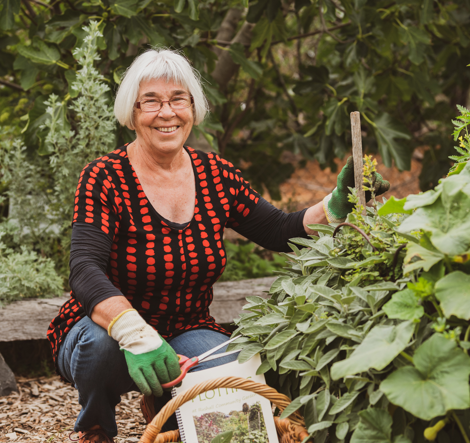 Rushall Garden volunteer Lynda posing in the garden with her new book Plotting
