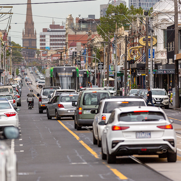 a group of cars and a cyclist sharing Brunswick Street in Fitzroy