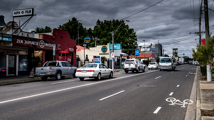 Heidelberg Road with cars and trucks on the road passing by shopfronts